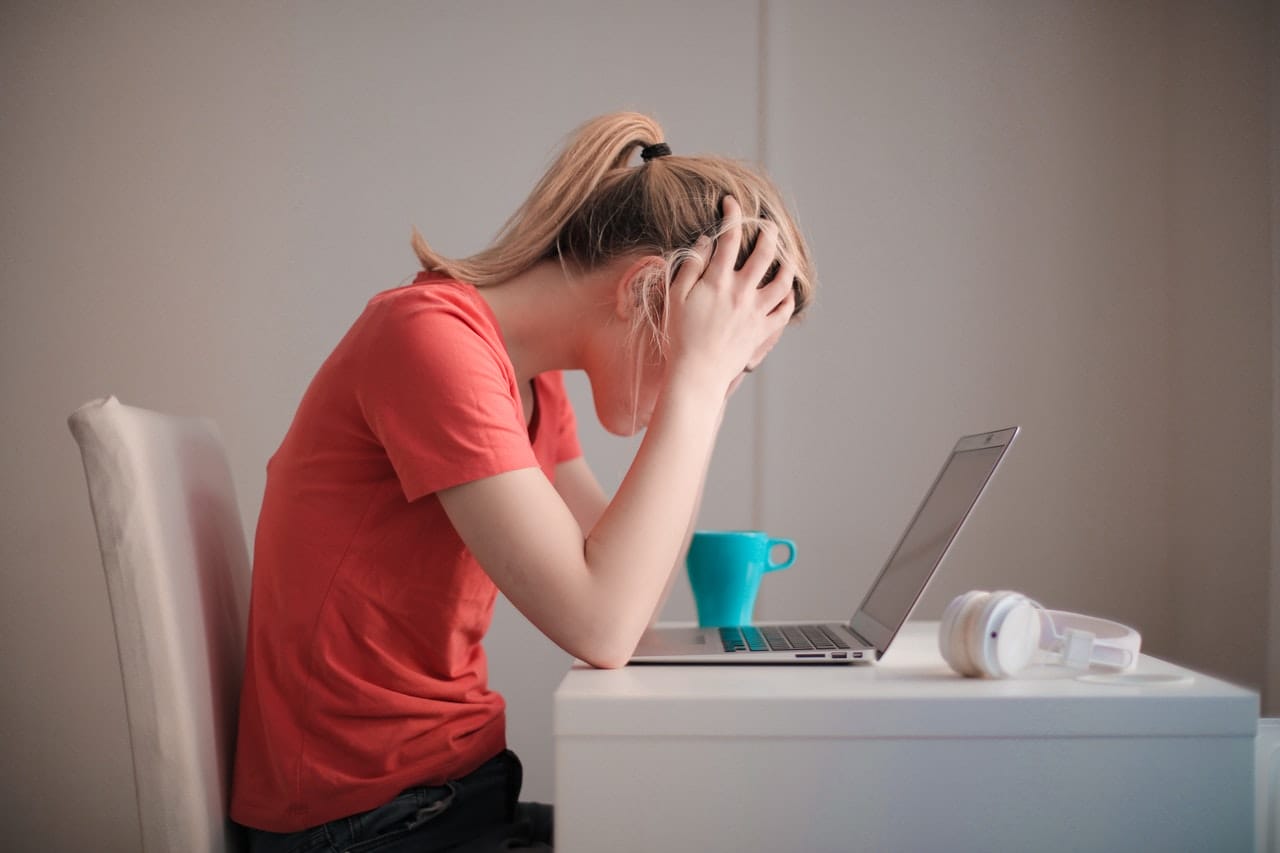 Dame die achter haar MacBook zit en vergeten is een bestand op te slaan
